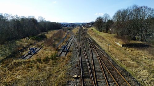 Railroad tracks amidst trees against sky