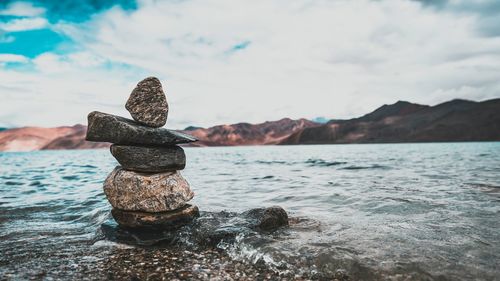 Close-up of rocks in sea against sky