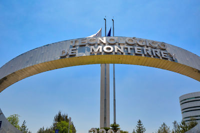 Low angle view of sign against clear blue sky