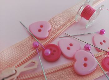 High angle view of pink sewing items on table