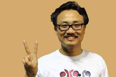 Portrait of smiling young man against gray background