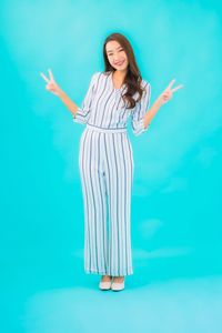 Young woman standing against blue background