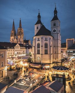 Illuminated cathedral in city at dusk