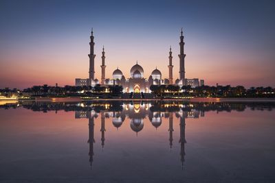 Reflection of buildings in lake at sunset