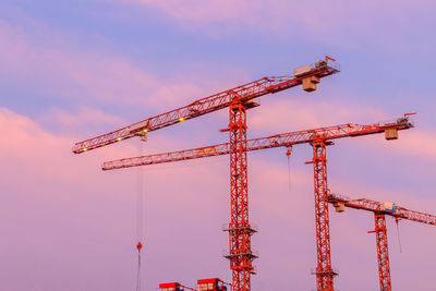 Cranes at construction site against sky