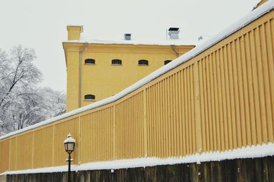 Yellow house against sky during winter