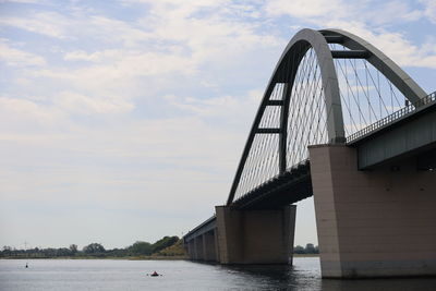 Low angle view of bridge over river against sky