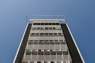 Low angle view of office building against clear blue sky