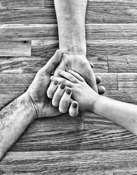 Cropped image of family with holding hands on table