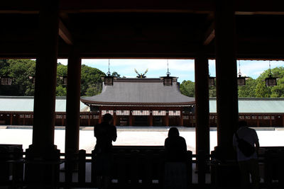 Rear view of silhouette people sitting in front of building