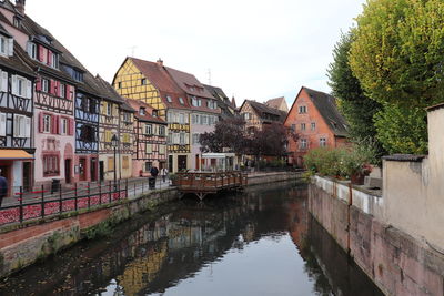 Canal amidst buildings against sky