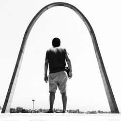 Rear view of man standing against clear sky