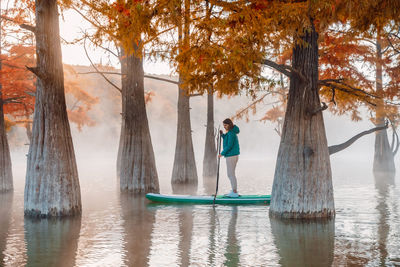 Rear view of woman standing in lake