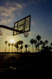 Low angle view of basketball hoop against sky during sunset