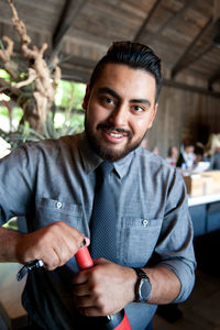 Portrait of bartender opening wine bottle