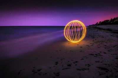 Burning steel wool firework on beach at night