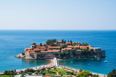 Scenic view of sea and buildings against clear sky