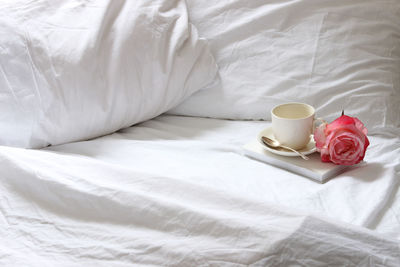 Close-up of coffee cup on bed 