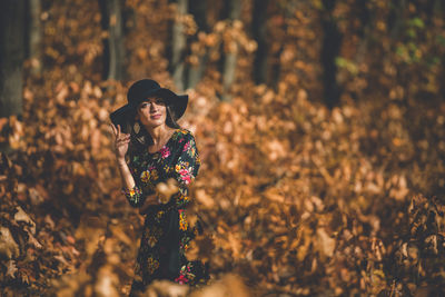 Young woman wearing hat standing on land