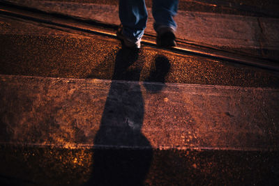 Low section of man standing on zebra crossing