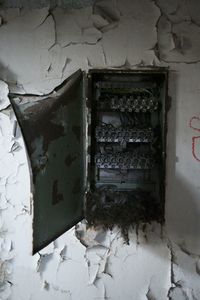 Bird nest in abandoned fuse box on wall