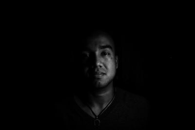 Portrait of man against black background