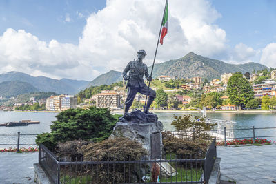 Nice monument of an alpino with the italian flag and omegna in the background