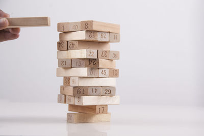 Stack of hand holding toy against white background