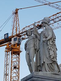 Low angle view of statue at construction site against sky