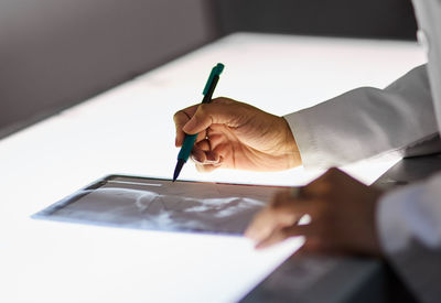 Midsection of man working on table