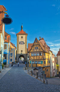 View of buildings in town against blue sky