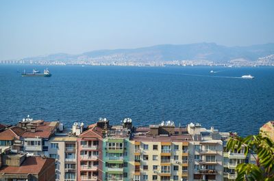 Boats in sea with buildings in background