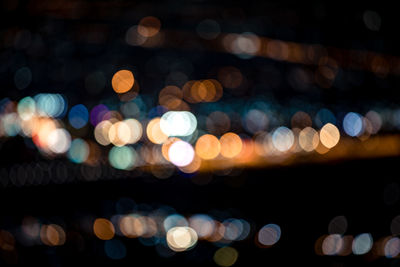 Abstract colorful bokeh of lights in the city at night on black background