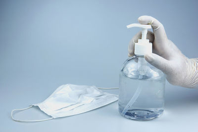 Person holding bottle against white background