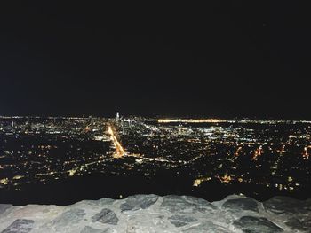 High angle view of illuminated buildings against sky at night