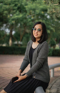 Portrait of young woman sitting on bench