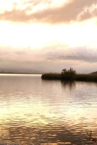 Scenic view of lake against sky at sunset