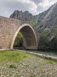 Arch bridge over river against sky