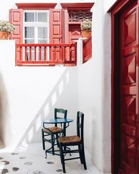 Empty chairs and tables against building