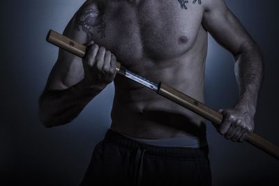 Midsection of man holding samurai sword