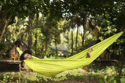 A back pack traveller taking a nap in the hammock.
