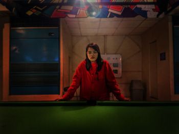 Portrait of woman standing by pool table