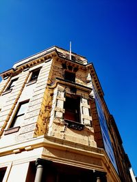 Low angle view of buildings against clear blue sky