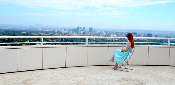 Full length of woman looking at river in city