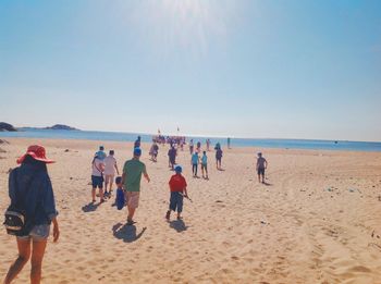 People at beach against clear sky