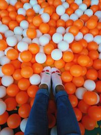 Low section of woman on orange and white balls