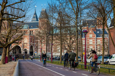 People walking on road amidst buildings in city