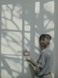 Portrait of woman standing by wall outdoors