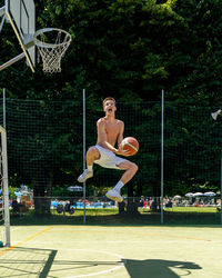 Young caucasian basketball player athlete in action jumping on artificial turf playing field