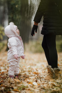 Rear view of women standing on street during autumn